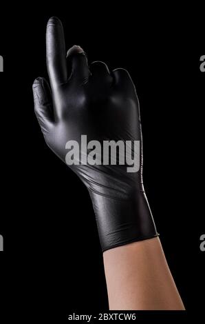 Main dans des gants noirs avec l'index orienté vers le haut sur le noir Banque D'Images