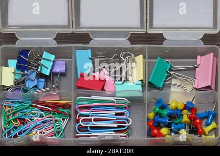 Papeterie scolaire colorée fournitures de papier-clips et broches dans boîte en plastique Banque D'Images