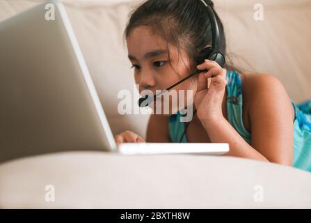 asiatique fille élève porter casque regarder webinar écouter cours en ligne communiquer par conférence appel vidéo. . Homeschooling et l'apprentissage à distance, onli Banque D'Images