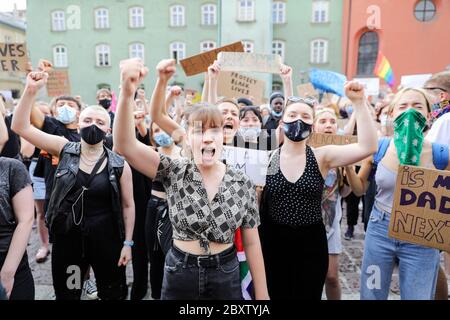 De jeunes manifestants branle leurs poings et crient des slogans anti-racistes pendant la manifestation Black Lives Matter.des centaines de jeunes ont participé à la manifestation « Black Lives Matter » à Cracovie, la plus grande ville du sud de la Pologne. Ils ont rendu hommage à George Floyd et ont exprimé leur désapprobation de la brutalité policière et du racisme. Banque D'Images