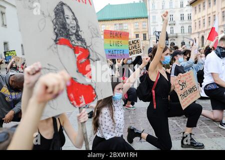 Cracovie, Pologne, Pologne. 7 juin 2020. Les manifestants se tiennent un genou tandis qu'un autre tient en hauteur un écriteau représentant une femme afro-américaine pendant la manifestation Black Lives Matter.des centaines de jeunes ont participé à la manifestation « Black Lives Matter » à Cracovie, la plus grande ville du sud de la Pologne. Ils ont rendu hommage à George Floyd et ont exprimé leur désapprobation de la brutalité policière et du racisme. Crédit: Filip Radwanski/SOPA Images/ZUMA Wire/Alay Live News Banque D'Images