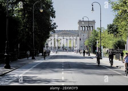 Porte de la ville de Propylaea à l'ouest de Königsplatz à Munich, en Allemagne, avec des cyclistes le long de la route Banque D'Images