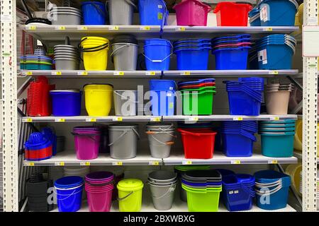 Étagères dans le magasin avec des plats en plastique. Alternative peu coûteuse aux plats faits de matériaux naturels. Couleurs des paniers, bols et bassins en plastique Banque D'Images