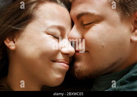 Portrait émotionnel d'un couple souriant affectueux, vue rapprochée. Petit ami et petite amie amoureux, de vraies personnes. Banque D'Images