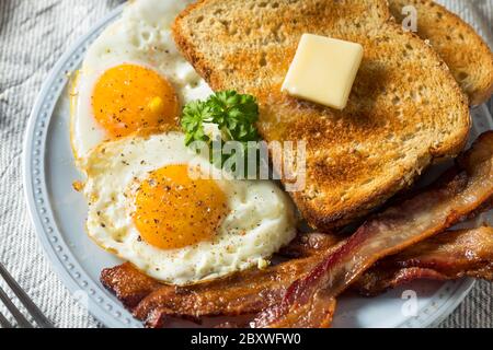 Œufs de Sunnyside faits maison petit-déjeuner avec pain grillé et bacon Banque D'Images