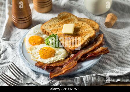 Œufs de Sunnyside faits maison petit-déjeuner avec pain grillé et bacon Banque D'Images