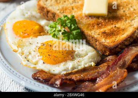 Œufs de Sunnyside faits maison petit-déjeuner avec pain grillé et bacon Banque D'Images
