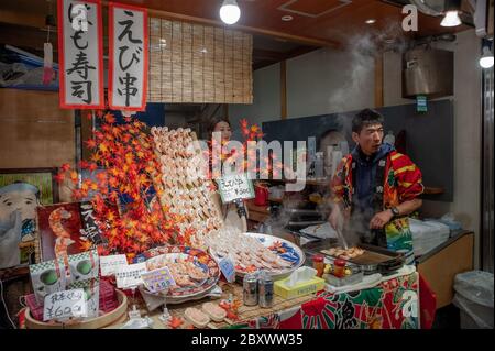 Un vendeur au marché Nishiki également connu sous le nom de cuisine Kyotos vendant des aliments Banque D'Images