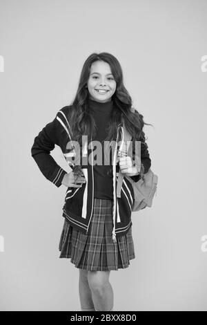 Petite fille porter l'uniforme scolaire. Enseignement primaire, secondaire et supérieur. L'Éducation Au Royaume-Uni. Étudiant en anglais. Sac à dos pour enfant anglais. Programme d'éducation britannique. Apprendre la langue étrangère. Banque D'Images