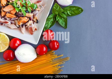 Spaghetti, tomates cerises, oignons, basilic, citron et moules - les meilleurs ingrédients pour les pâtes italiennes.heathy concept alimentaire Banque D'Images