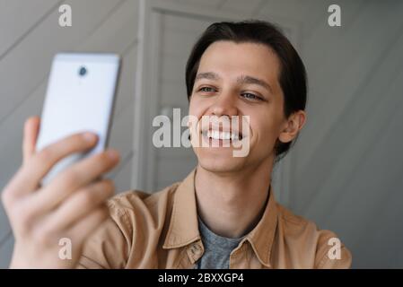 Hipster tenant le téléphone mobile, prendre des photos, rire. Blogger réussi à diffuser des vidéos en ligne à l'aide d'un smartphone. Banque D'Images