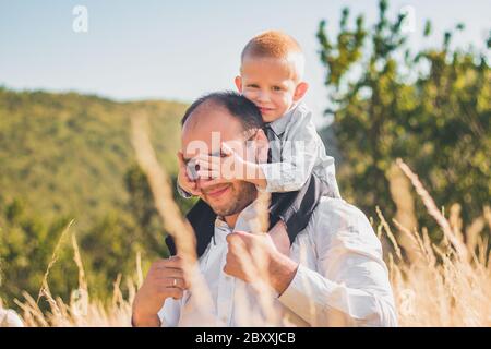 Bonne famille avec les enfants marchant ensemble dans le champ de blé le jour d'été chaud et ensoleillé. Mise au point douce. Banque D'Images
