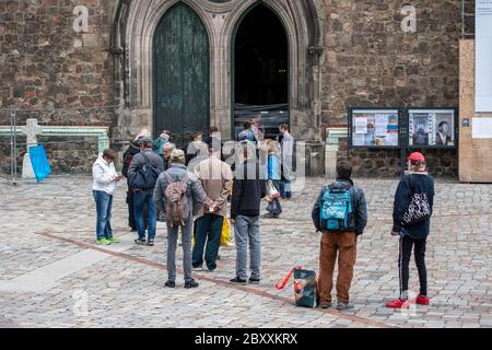 Groupe de personnes attendant de la nourriture gratuite dans une ligne devant une église à Berlin. Église Sainte-Marie, Marienkirche Banque D'Images