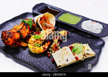 Plateau tandoori avec tikka de poulet, crevettes grillées et paneer avec makhani de dal, pain de blé et chutneys, spécialité indienne Banque D'Images
