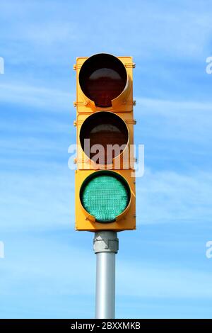 Lampe de signalisation de circulation vert contre le ciel bleu Banque D'Images