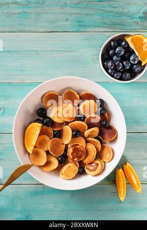 Vue de dessus sur les mini crêpes tendance sur fond turquoise clair Banque D'Images