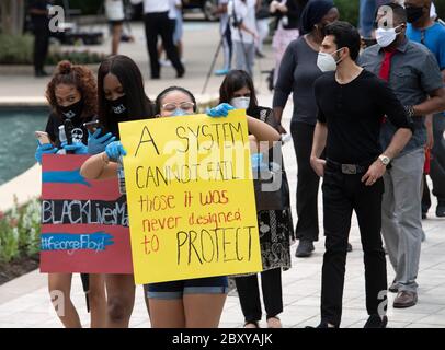 Houston, TX USA 8 juin 2020 : des jeunes femmes portant des panneaux de protestation faits main attendent dans la file de l'église Fountain of Loupment dans le sud-ouest de Houston lors d'une visite publique de six heures pour GEORGE FLOYD, un homme noir tué il y a deux semaines par un policier blanc à Minneapolis. La mort de Floyd a suscité des manifestations dans le monde entier contre le racisme et la brutalité policière. Crédit : Bob Daemmrich/Alay Live News Banque D'Images
