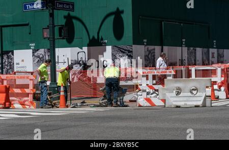 New York, NY - 8 juin 2020 : les ouvriers de la construction réparent le trottoir de la 3e Avenue à Manhattan le 1er jour de la réouverture Banque D'Images