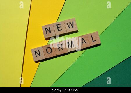 Nouveau Normal, mots en lettres de l'alphabet en bois 3d isolées sur fond jaune et vert Banque D'Images