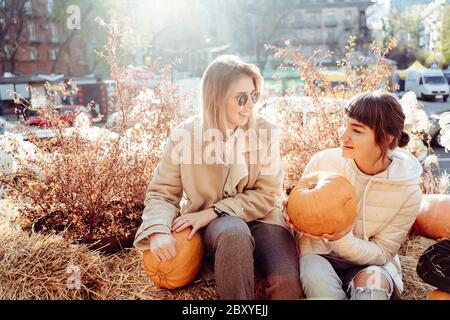 Les filles tient les citrouilles dans les mains sur le fond de la rue. Banque D'Images