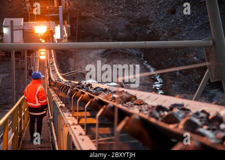 Nyngan Australie 20 juin 2012 : image de faible profondeur de champ d'un mineur inspectant des roches de minerai sur un convoyeur en Nouvelle-Galles du Sud Australie Banque D'Images