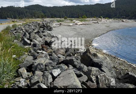 Le riprap longe le côté océan de la route de Whiffin Spit à Sooke, en Colombie-Britannique, au Canada, sur l'île de Vancouver. Le matériau de la carte est de la roche ou d'autres matériaux placés le long Banque D'Images