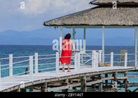 Mantanani Island, Sabah, Malaisie-VERS SEPTEMBRE, 2017:jeunes femmes d'Asie en rouge s'amuser à la jetée en bois de l'île Mantanani, Kota Belud, Sabah, Banque D'Images