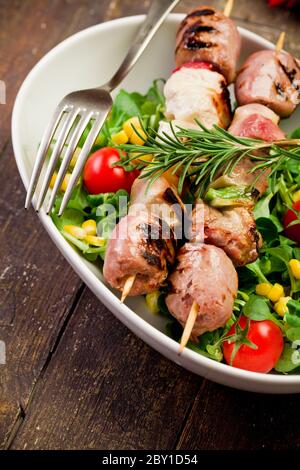 Brochettes de viande sur table en bois Banque D'Images