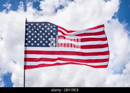 Gros plan sur une étoile magnifique et un drapeau américain rayé ; concept pour le Memorial Day ou le 4 juillet ; fond de nuages blancs Banque D'Images