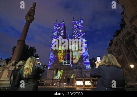 Les spectateurs regardent des images de Charles Dickens projetées sur les tours ouest de l'abbaye de Westminster à Londres pour marquer le 150e anniversaire (mardi) de la mort de l'un des plus grands auteurs du pays. Le doyen de Westminster, le très révérend David Hoyle, posera une couronne et prononceront des prières à la tombe de l'écrivain dans le transept sud de l'abbaye. Banque D'Images