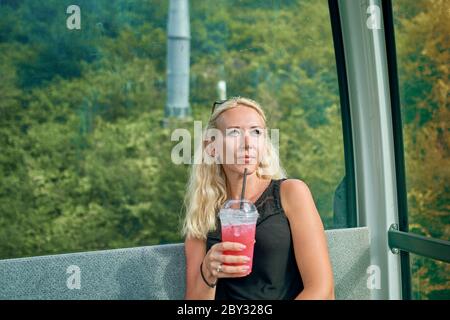 fille avec un cocktail dans la cabine de la remontée mécanique Banque D'Images