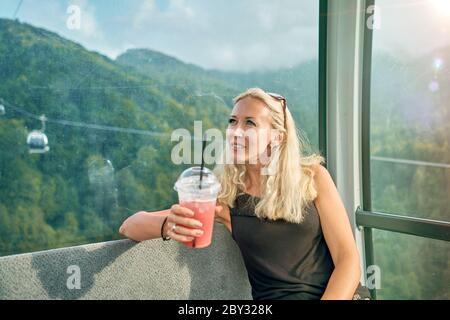 fille avec un cocktail dans la cabine de la remontée mécanique Banque D'Images