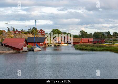 Hangars à bateaux traditionnels rouge falu à Harstena, une île sur la côte est de la Suède dans la mer Baltique Banque D'Images