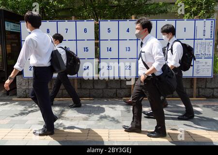 Des piétons portant des masques de visage marchent devant un panneau d'affichage érigé spécialement pour les affiches des candidats pour l'élection du gouverneur de Tokyo le 5 juillet, le 9 juin 2020, Tokyo, Japon. La période de campagne commence officiellement le 18 juin. Credit: Rodrigo Reyes Marin/AFLO/Alay Live News Banque D'Images