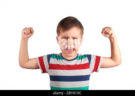 Le bébé garçon de sports de Cry montre émotionnellement sa force musculaire biceps de bras avec des haltères sur un fond bleu gris Banque D'Images