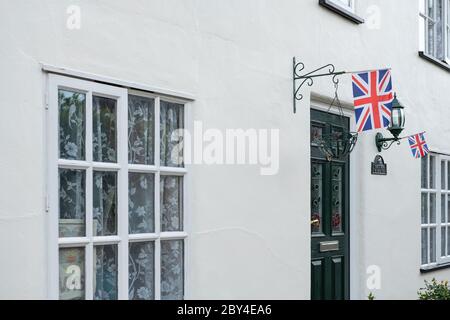 Drapeau Union Jack vu attaché aux ouvrages de fer d'un grand chalet indépendant. Vu pendant les célébrations de la journée de VE, un panneau de soutien NHS est vu dans une fenêtre Banque D'Images