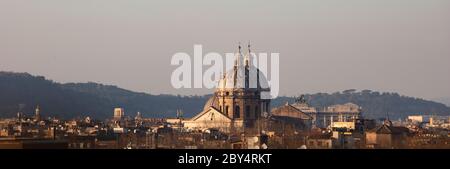 Vue sur les toits de Rome au coucher du soleil en hiver. Les dômes de San Carlo ai Catinari et Sant'Andrea della valle sont en train de prendre la lumière du soir. Banque D'Images