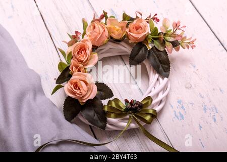 Couronne d'automne attachée avec un noeud en toile de jute sur un fond de planche en bois de shabbi abîmé. Banque D'Images