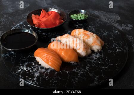 Délicieux sushi servi sur une ardoise en pierre sombre. Fond noir Banque D'Images