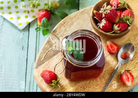 Concept de conservation maison. Sirop de fraise et baies de fraise fraîches sur une table en bois. Copier l'espace. Banque D'Images