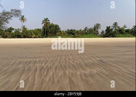 Photographie de motifs abstraits naturels sur la plage, créés par du sable humide et de petites vagues Banque D'Images