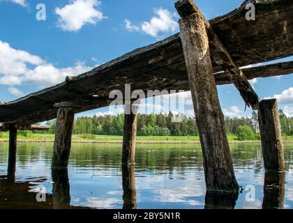 paysage d'été avec une vieille passerelle en bois dans un petit lac forestier Banque D'Images