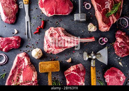 Ensemble de viandes de boucherie, différents steaks de bœuf avec ustensiles de cuisine et de cuisson - fourchette à viande et nettoyant pour bouchers et couteau à herbes. Banque D'Images