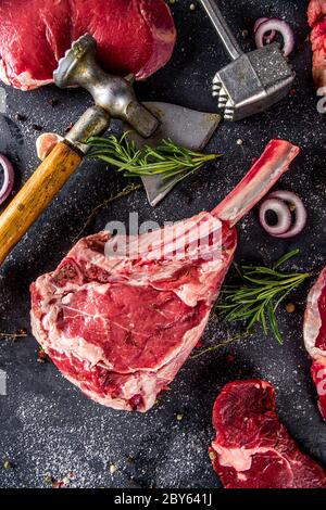 Ensemble de viandes de boucherie, différents steaks de bœuf avec ustensiles de cuisine et de cuisson - fourchette à viande et nettoyant pour bouchers et couteau à herbes. Banque D'Images