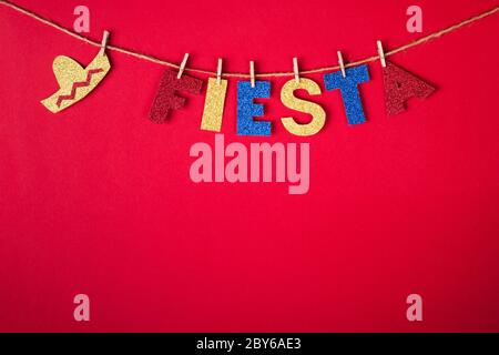 Fiesta Word et sombrero sur des épingles en papier brillant sur fond rouge. Concept Cinco de mayo. Banque D'Images