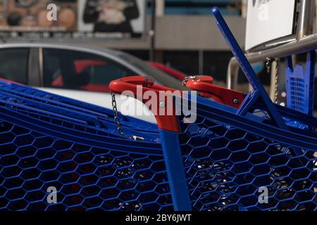 Les chariots, de couleur bleue et en plastique, sont rangés dans le parking extérieur d'un grand centre commercial, à Madrid. Banque D'Images