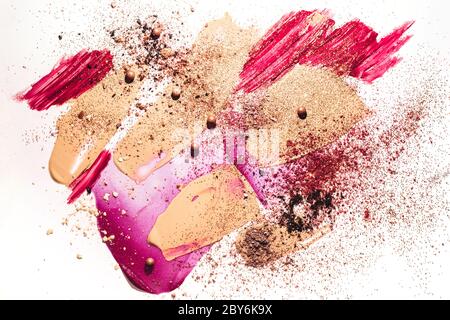 Concept de beauté avec fond de teint massé, ombres cassées, brillant à lèvres et taches sur fond blanc. Banque D'Images