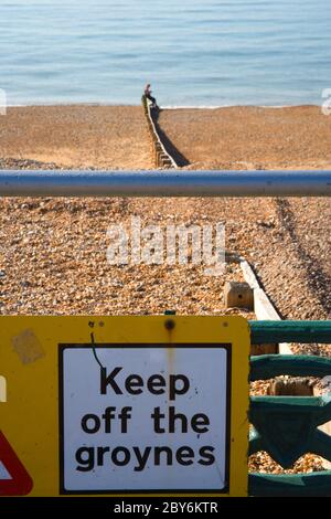 Marcher sur les épis signe à Hove sur la côte du Sussex de l'Est Banque D'Images