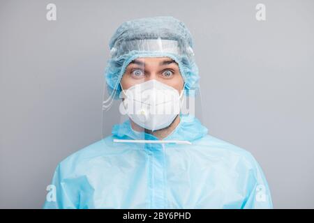 Gros plan photo de beau gars expert doc virologie centre grands yeux plein de peur porter masque respiratoire bleu hazmat uniforme costume plastique visage Banque D'Images