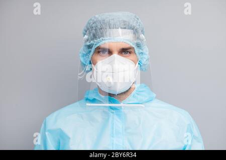 Gros plan photo de beau gars expert doc virologie centre clinique porter masque respiratoire bleu noismat uniforme costume plastique masque de protection faciale Banque D'Images